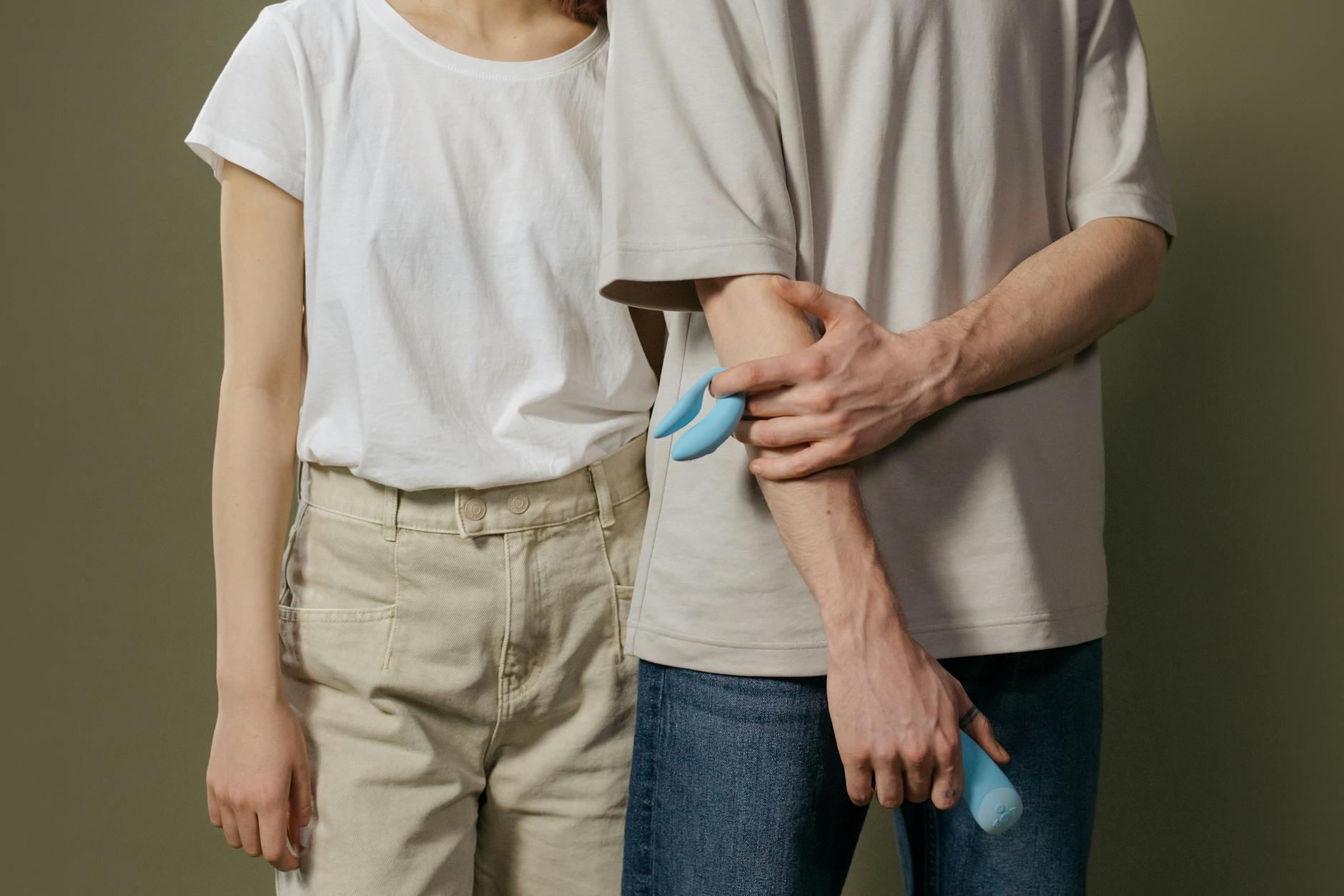 Casal jovem segurando vibrador azul em relacionamento longo